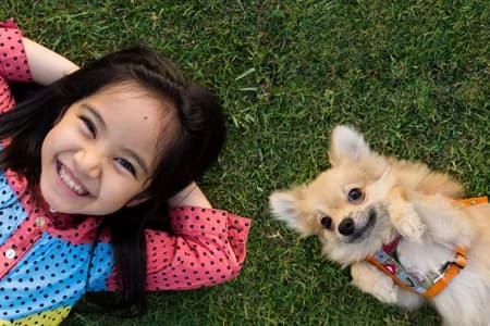 Girl laying in the grass with her dog